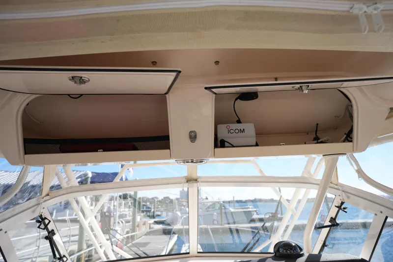 Slide: The Image of 2023 Grady-White Marlin 300 boat interior with storage compartments and ICOM equipment. - 51