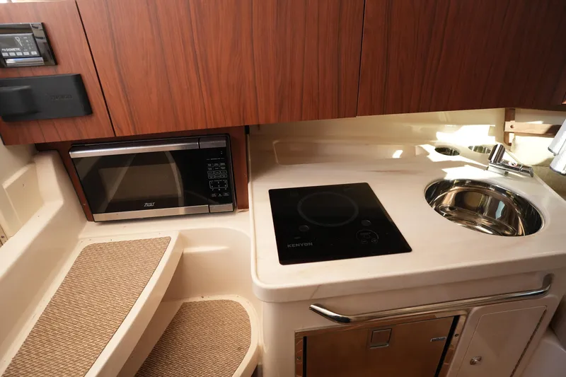 Slide: The Image of 2023 Grady-White Marlin 300 boat interior with kitchenette, microwave, and sink. - 55