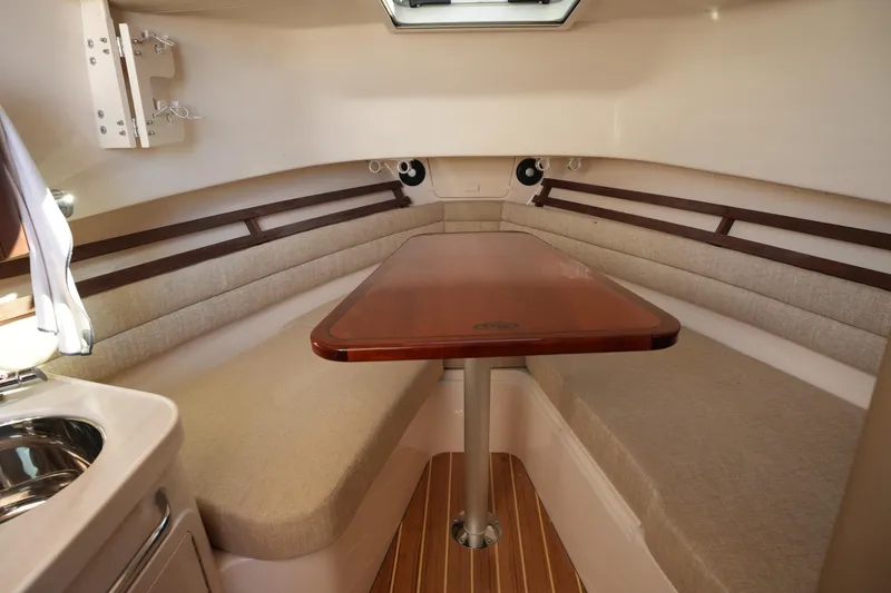 Slide: The Image of 2023 Grady-White Marlin 300 cabin interior with wooden table and cushioned seating. - 57