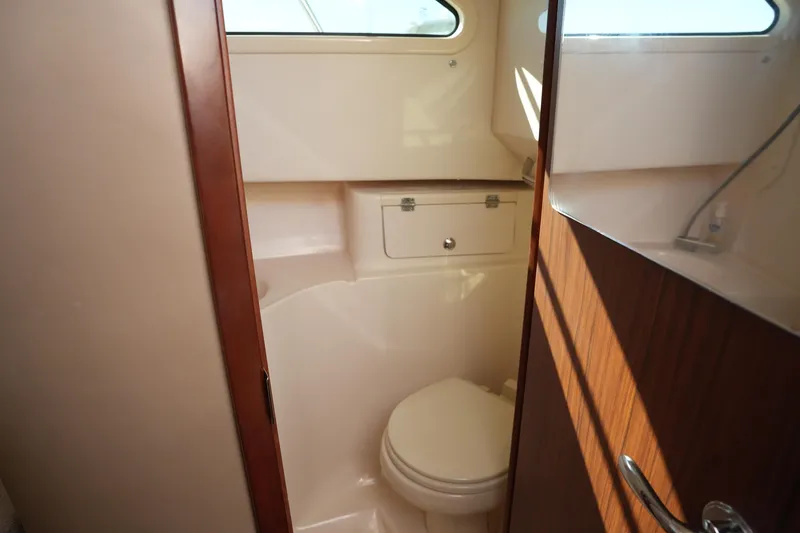Slide: The Image of 2023 Grady-White Marlin 300 boat interior bathroom with compact design and wooden accents. - 59