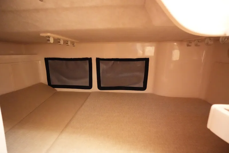 Slide: The Image of 2023 Grady-White Marlin 300 cabin interior with cozy sleeping area and windows. - 62