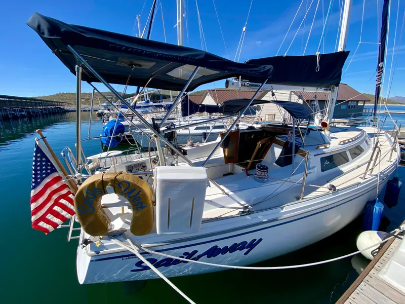 Slide: The Image of 1989 Catalina 36 sailboat docked with American flag. - 6