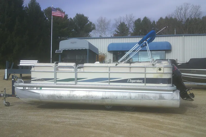 The Image of 1998 Premier 210 Sunsation pontoon boat parked outdoors near a building. - 1