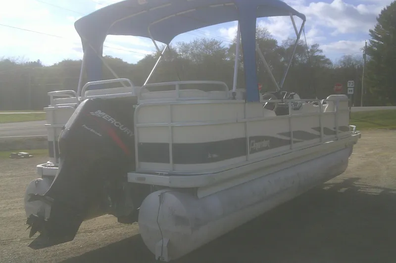 Slide: The Image of 1998 Premier 210 Sunsation pontoon boat with Mercury outboard motor, parked outdoors. - 3