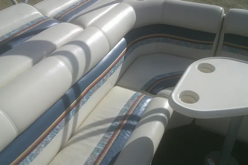 Slide: The Image of 1998 Premier 210 Sunsation boat interior with cushioned seating and a small table. - 7
