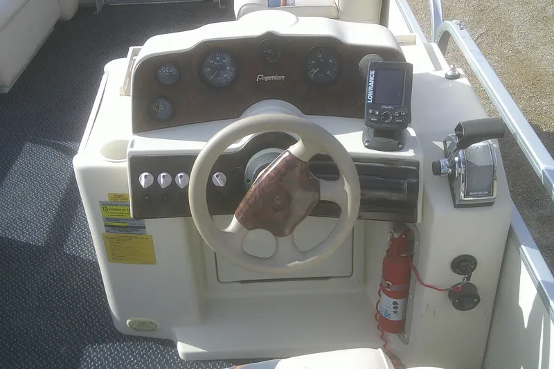 Slide: The Image of 1998 Premier 210 Sunsation boat dashboard with steering wheel, gauges, and navigation equipment. - 9