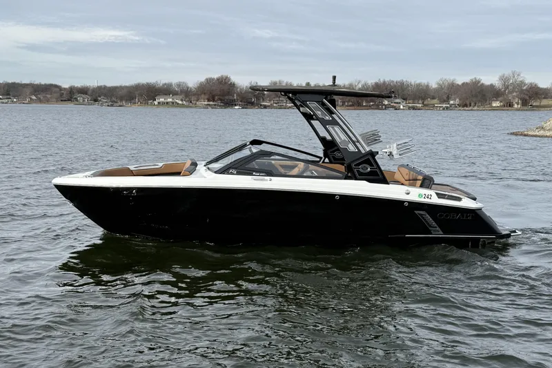 The Image of 2022 Cobalt R4 Surf boat on a calm lake with scenic background. - 0