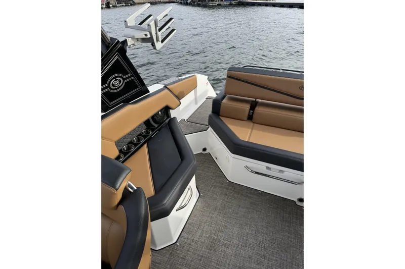 Slide: The Image of 2022 Cobalt R4 Surf boat interior with tan and black seating by the water. - 13
