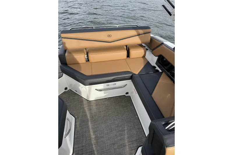 Slide: The Image of 2022 Cobalt R4 Surf boat interior with tan and black seating, on water. - 15