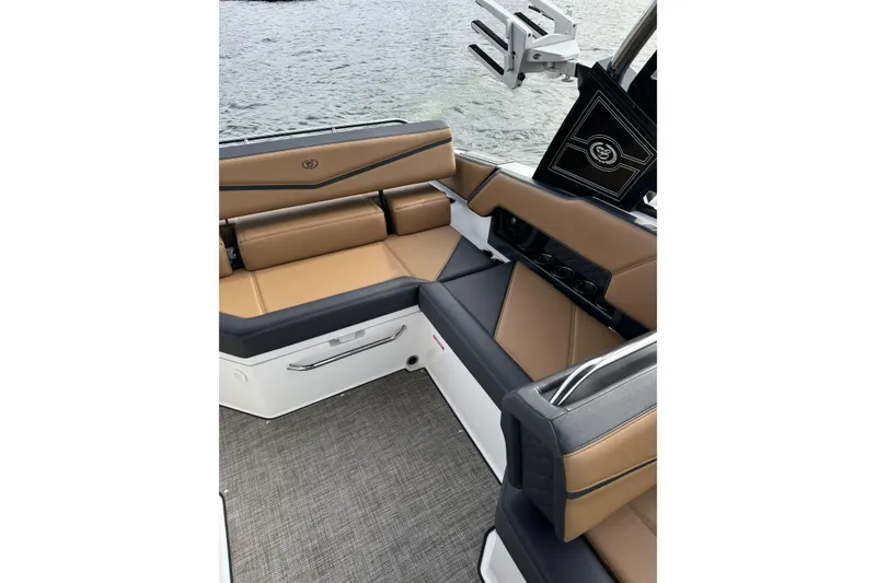 Slide: The Image of 2022 Cobalt R4 Surf boat interior with tan and black seating, near water. - 16