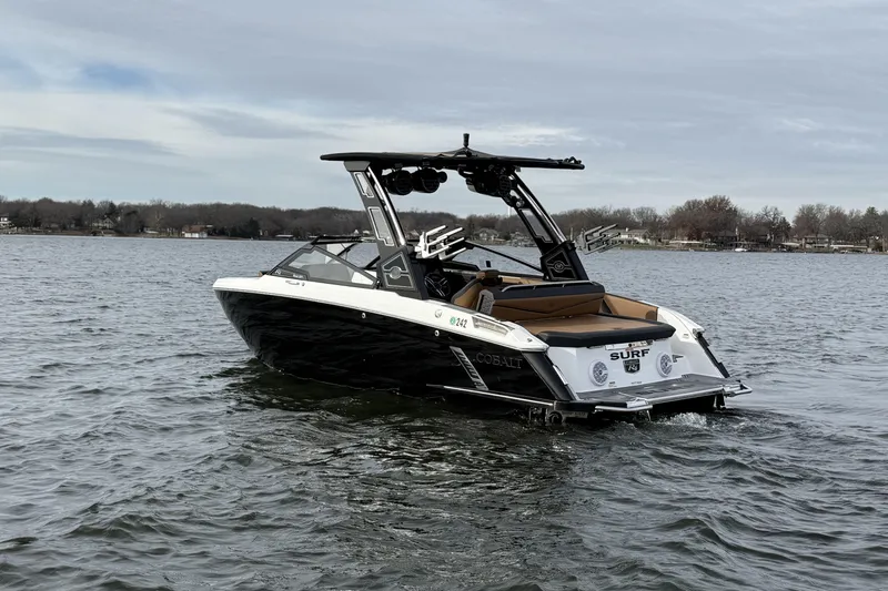 Slide: The Image of 2022 Cobalt R4 Surf boat on a lake, showcasing sleek design and modern features. - 2
