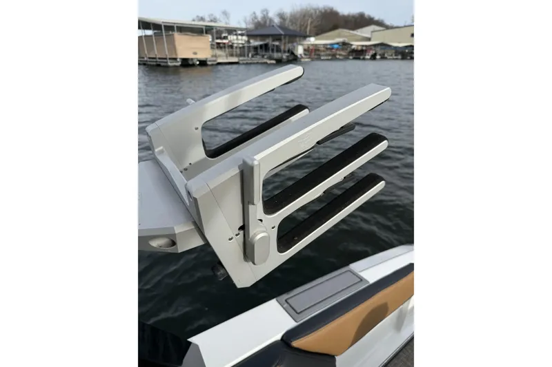 Slide: The Image of 2022 Cobalt R4 Surf boat with a wakeboard rack on a lake. - 26