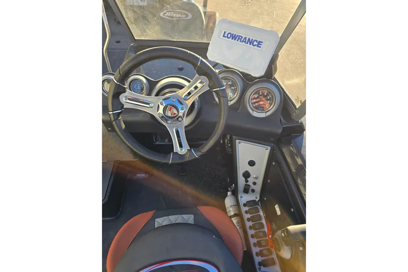 Slide: The Image of 2022 Triton 186 Fishunter boat dashboard with steering wheel and Lowrance display. - 4