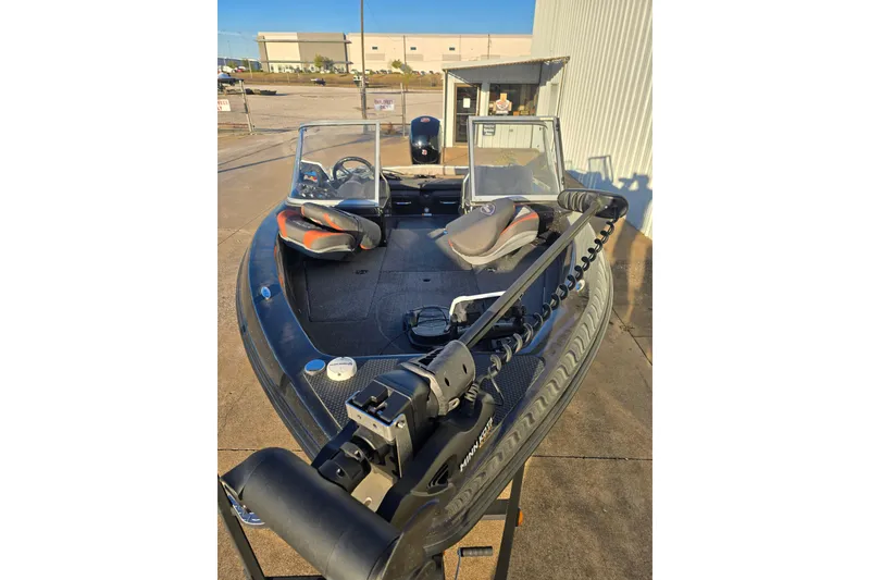 Slide: The Image of 2022 Triton 186 Fishunter boat with dual seats and trolling motor, parked outdoors. - 6