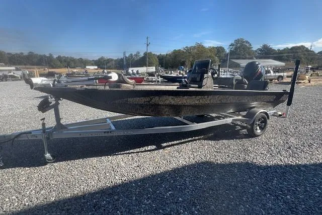 Slide: The Image of 2026 Xpress XP20CC boat on trailer in gravel lot, clear sky background. - 10