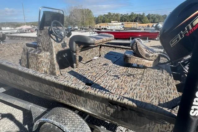 Slide: The Image of 2026 Xpress XP20CC boat with camouflage design, featuring steering console and seating, parked outdoors. - 4