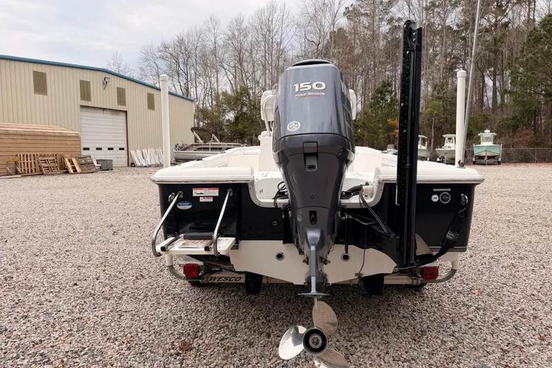 Slide: The Image of 2012 Sea Hunt BX 22 Pro boat with 150 horsepower engine, parked on gravel. - 2