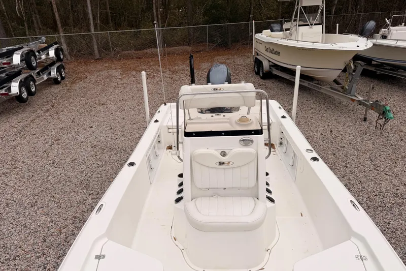 Slide: The Image of 2012 Sea Hunt BX 22 Pro boat in a gravel lot, surrounded by trailers and other boats. - 5