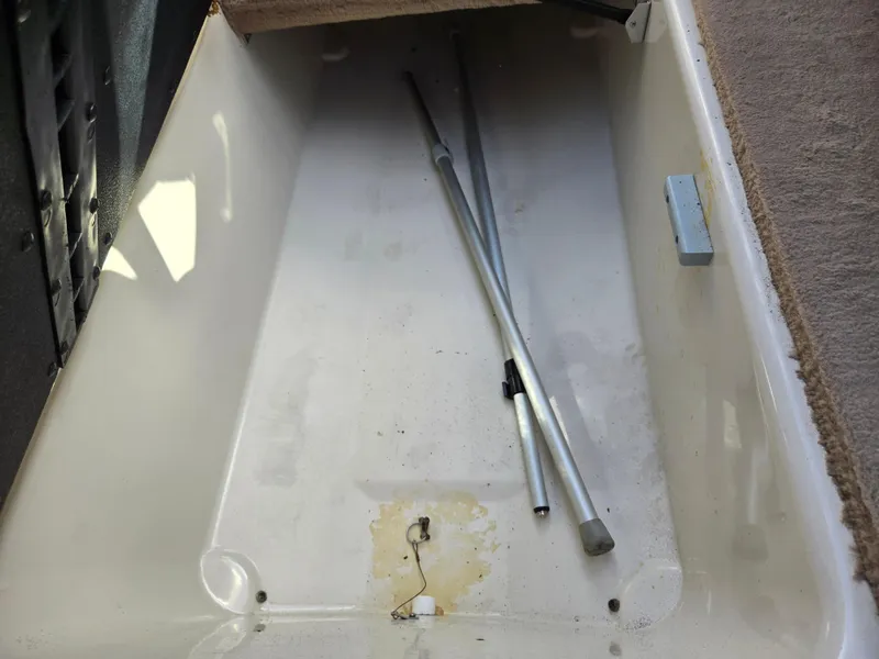Slide: The Image of Storage compartment of a 1999 Sea Ray 210 BR boat with metal poles inside. - 12