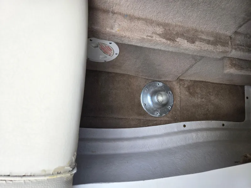 Slide: The Image of Interior of a 1999 Sea Ray 210 BR boat showing carpeted flooring and seat base. - 25