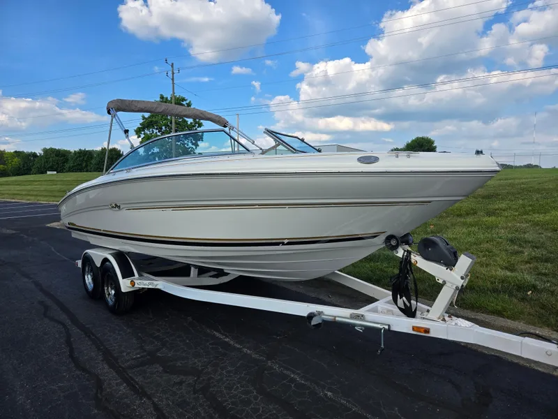 Slide: The Image of 1999 Sea Ray 210 BR boat on trailer under blue sky with clouds. - 5