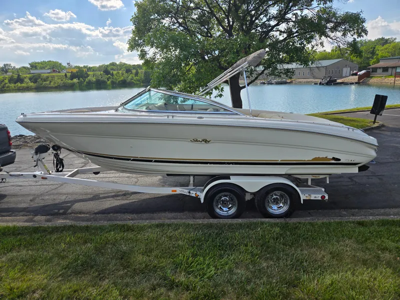 Slide: The Image of 1999 Sea Ray 210 BR boat on trailer by a lake, under a tree. - 9