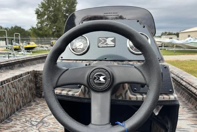 Slide: The Image of 2026 Xpress XP170 boat dashboard with steering wheel and gauges, featuring camo design. - 13