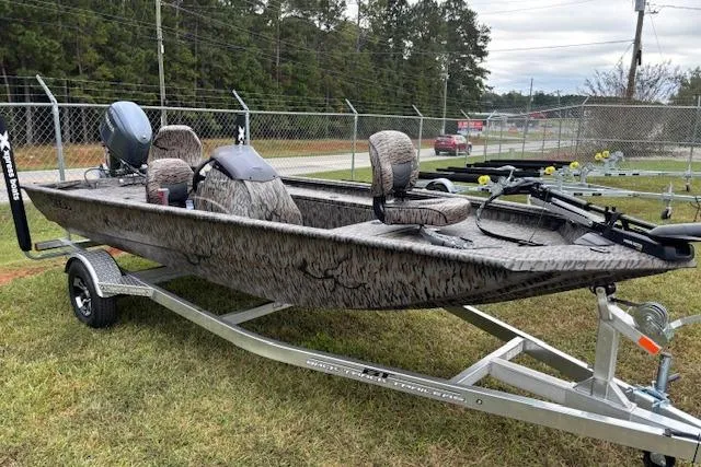 Slide: The Image of 2026 Xpress XP170 boat on trailer, camo design, parked on grass near fence. - 20