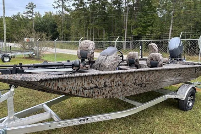Slide: The Image of 2026 Xpress XP170 boat with camouflage design on a trailer, parked outdoors. - 4