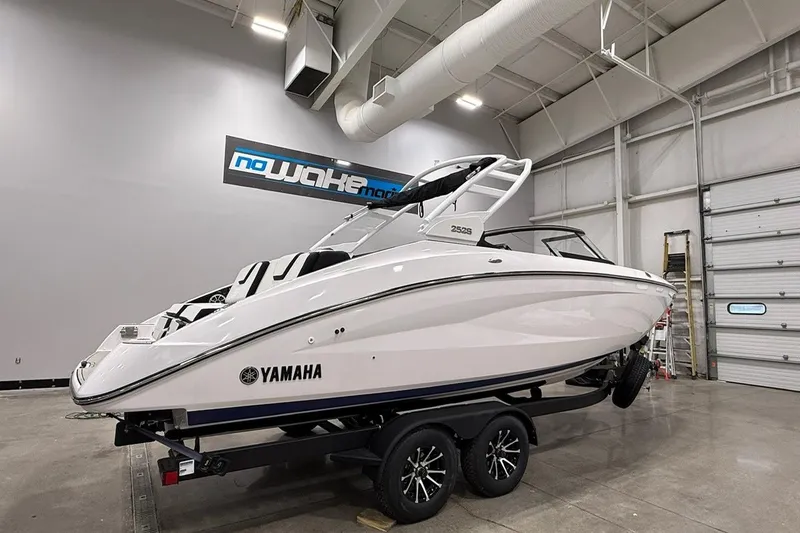 Slide: The Image of 2025 Yamaha Boats 252S in showroom, sleek design, on trailer, indoor display. - 2