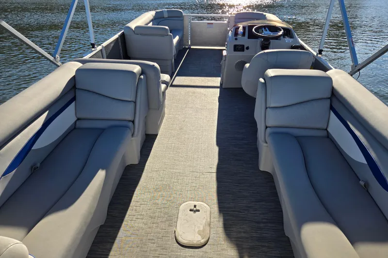Slide: The Image of 2023 Bennington 22 SSR pontoon boat interior with plush seating on a sunny day. - 10
