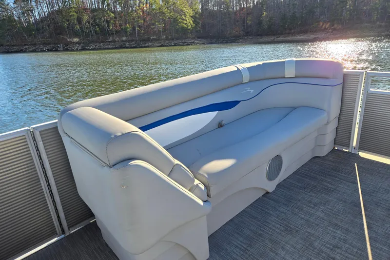 Slide: The Image of 2023 Bennington 22 SSR pontoon boat with comfortable seating on a serene lake. - 11