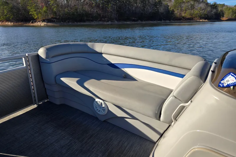 Slide: The Image of 2023 Bennington 22 SSR pontoon boat interior with comfortable seating on a serene lake. - 12