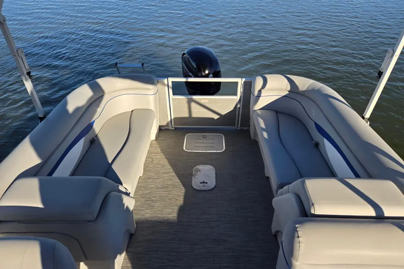 Slide: The Image of 2023 Bennington 22 SSR pontoon boat interior with plush seating on calm water. - 13