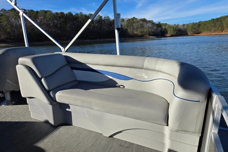 Slide: The Image of 2023 Bennington 22 SSR pontoon boat interior with comfortable seating on a serene lake. - 14