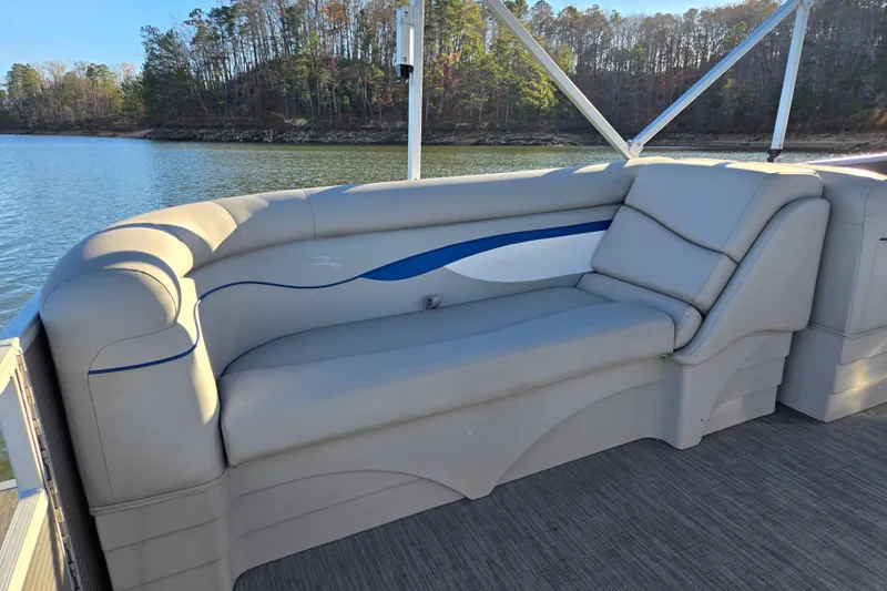 Slide: The Image of 2023 Bennington 22 SSR pontoon boat with comfortable seating on a serene lake. - 15