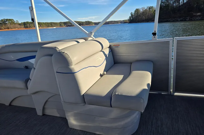 Slide: The Image of 2023 Bennington 22 SSR pontoon boat interior with comfortable seating on a serene lake. - 16