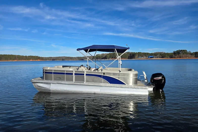 Slide: The Image of 2023 Bennington 22 SSR pontoon boat on a serene lake with blue skies. - 8
