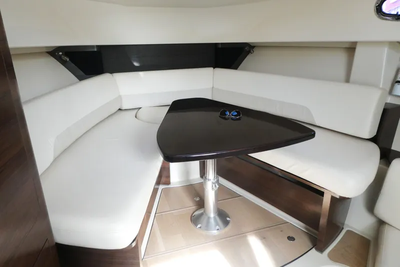 Slide: The Image of Interior of 2020 Boston Whaler 345 Conquest with white seating and dark wood table. - 13