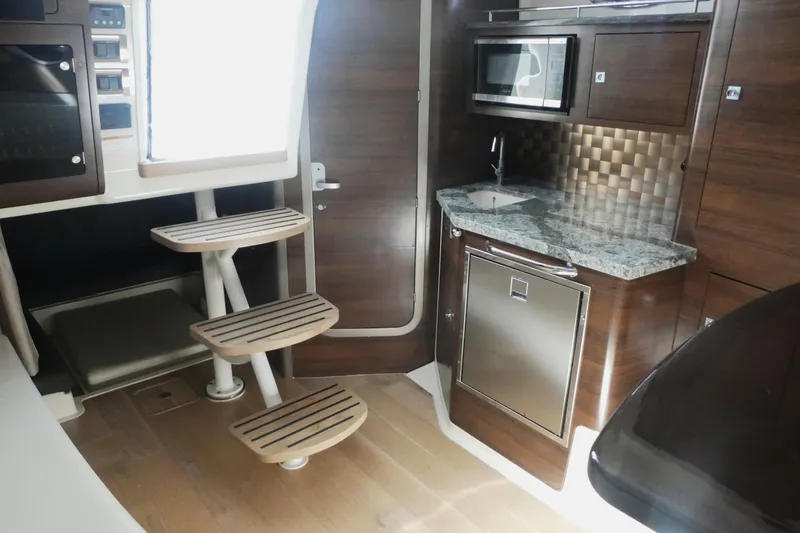 Slide: The Image of Interior of 2020 Boston Whaler 345 Conquest with modern kitchen and wooden stairs. - 15