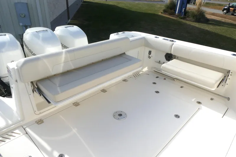 Slide: The Image of 2020 Boston Whaler 345 Conquest boat deck with seating and triple outboard engines. - 4
