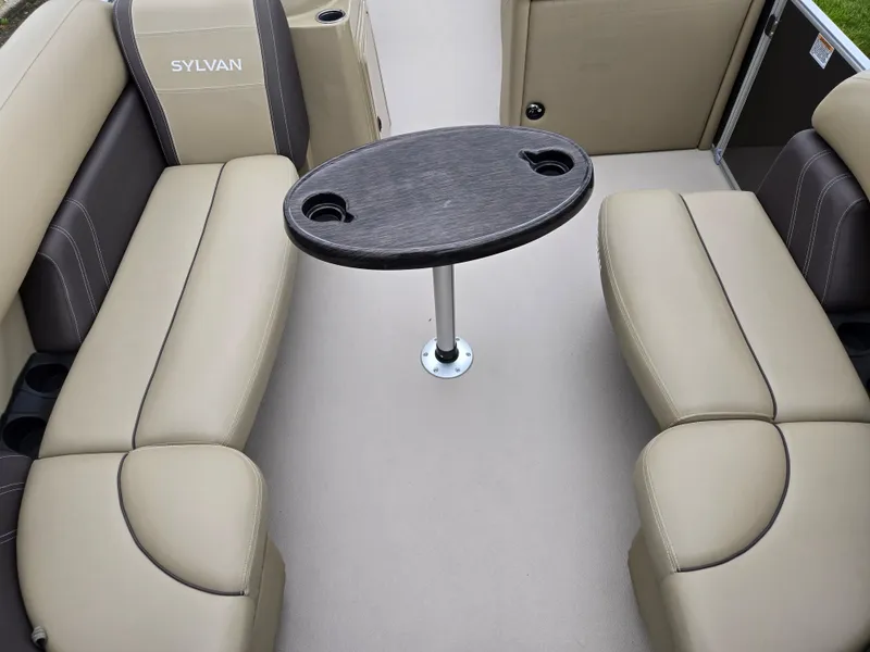 Slide: The Image of 2022 Sylvan Mirage Fish 822 Party Fish boat interior with beige seating and oval table. - 10