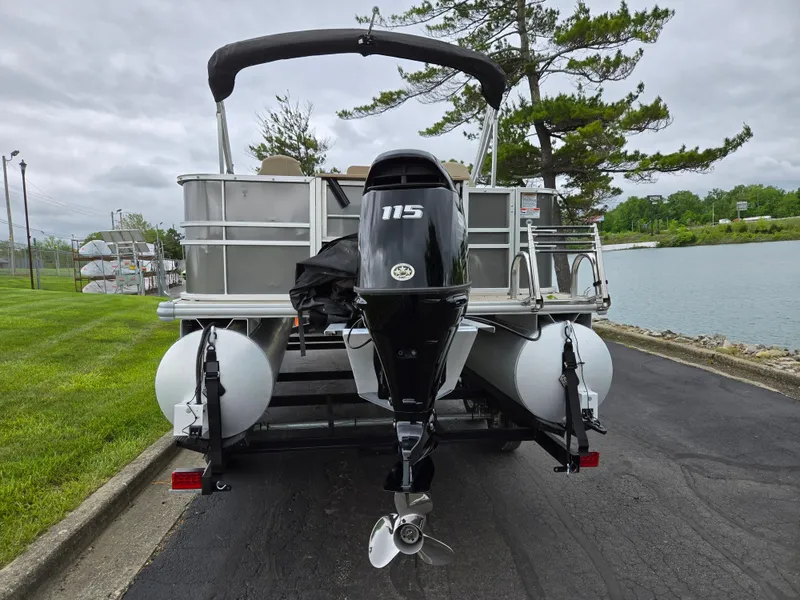 Slide: The Image of 2022 Sylvan Mirage Fish 822 Party Fish pontoon boat with 115 HP engine, parked by a lake. - 2