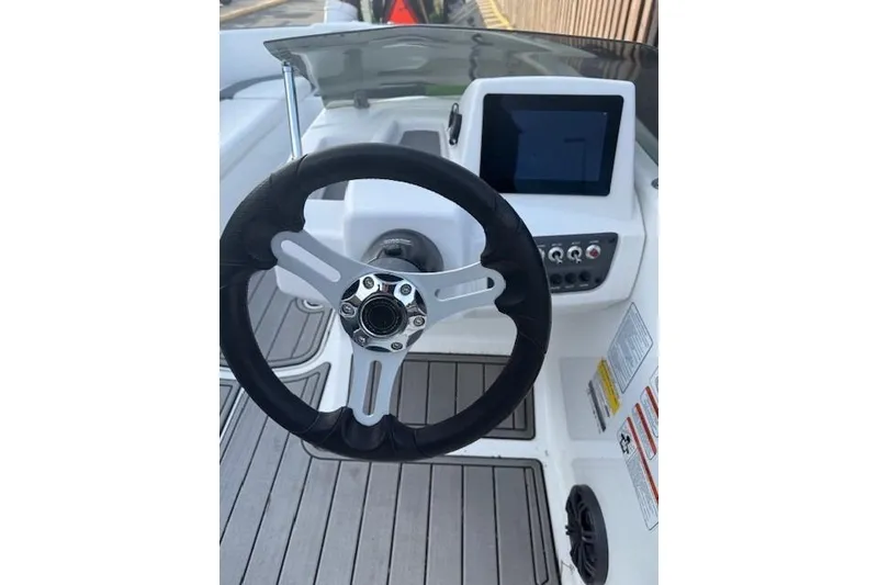 Slide: The Image of 2024 Tahoe T16 boat dashboard with steering wheel and control panel. - 3