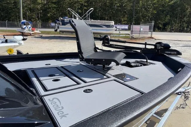 Slide: The Image of 2026 Xpress H18C Crappie boat with SeaDek flooring and fishing seat, parked outdoors. - 11