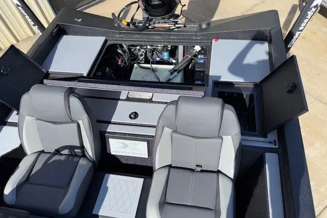 Slide: The Image of 2026 Xpress H18C Crappie boat interior with gray seating and open storage compartments. - 18