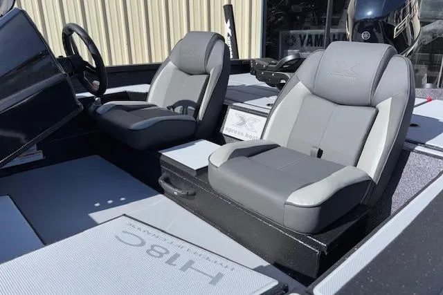 Slide: The Image of 2026 Xpress H18C Crappie boat interior with dual gray seats and steering wheel. - 4