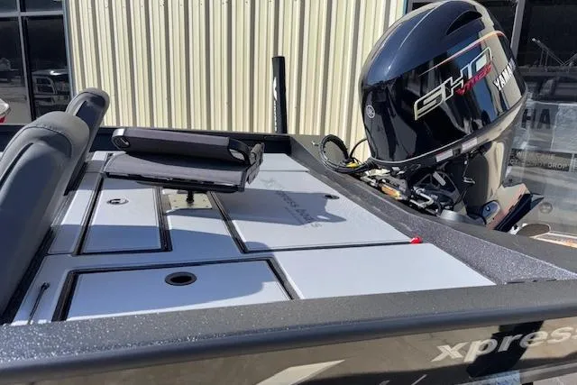 Slide: The Image of 2026 Xpress H18C Crappie boat with Yamaha engine, docked near a building. - 5