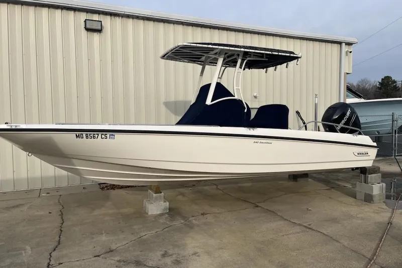 The Image of 2014 Boston Whaler Dauntless 240 boat on blocks, white hull, outdoor storage. - 1