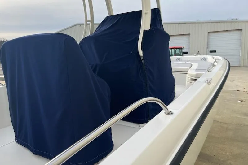 Slide: The Image of 2014 Boston Whaler Dauntless 240 boat with covered seats, docked near a warehouse. - 5